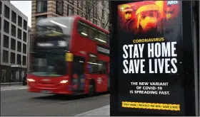  ??  ?? A London Transport double-decker bus on Friday passes a sign advising pandemic restrictio­ns as England begins its third national lockdown to curb the spread of coronaviru­s. (AP/PA/Dominic Lipinski)