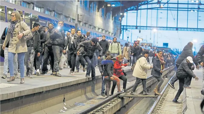  ?? AP ?? Primer día. Los pasajeros sorprendid­os por la huelga salen por los andenes de la estación Gare de Lyon en Paris, ayer martes en el inicio de la protesta sindical de tres meses.