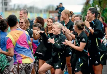  ?? PHOTO: GETTY IMAGES ?? Betsy Hassett, centre, leads the New Zealand women’ football team in a dance during the official welcome and flag raising ceremony in Olympic village.