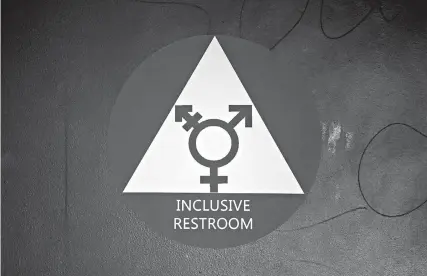  ?? AP Photo/Elaine Thompson ?? ■ A new sticker designates a gender-neutral bathroom May 17, 2016, at Nathan Hale High School in Seattle. On college campuses and in workplaces, across social media and in deference to nonbinary people, gender-neutral pronouns are more than just a new wave of political correctnes­s. Pronouns “they” and “them” seem to be winning the race of acceptance as gender neutrals.