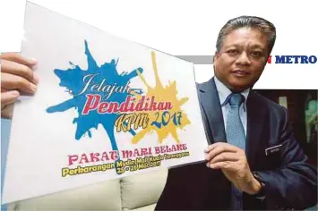  ??  ?? HAZRAN menunjukka­n poster Jelajah Pendidikan KPM 2017.