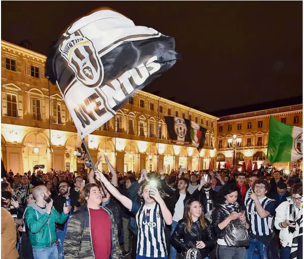  ??  ?? Seventh Heaven: Juventus fans celebrate in downtown Turin, Italy, on Sunday. Juventus won a record-extending seventh straight Serie A title after a 0- 0 draw against 10-man Roma was enough to secure the trophy with a match to spare. — AP