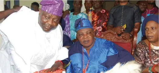  ??  ?? DCP Adegoke Fayoade (left) presenting the chieftainc­y beads of retired IG Tafa Balogun, who was installed as Oluomo of Igbominala­nd, to the Orangun of Ila, Oba Wahab Oyedotun as the monarch’s wife, Olori Abosede looks on