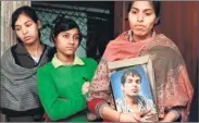  ??  ?? Family of Chandrakan­t Singh poses with his photo at their Fatehpur Beri house.