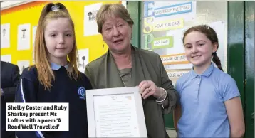  ??  ?? Shelby Coster and Ruby Sharkey present Ms Loftus with a poem ‘A Road Well Travelled’