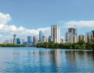  ?? Foto: Heike Schmidt/tmn ?? Die Skyline von Austin, davor der Lady Bird Lake – in der texanische­n Metropole hält der Bauboom weiterhin an und die Kräne prägen das Stadtbild.