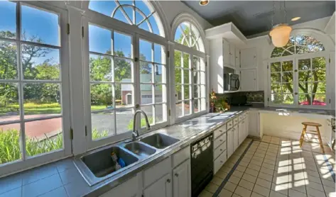  ?? From above: ?? Main entry with original turned staircase and 9½ -foot ceiling. The updated kitchen has several arched windows.