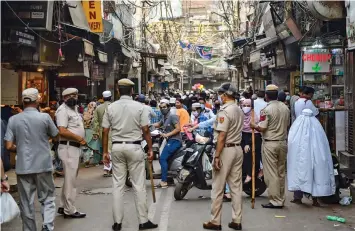  ?? — PTI ?? Police try to manage crowd in the view of Covid pandemic on the eve of Id-al-Fitr around Jama Masjid in Delhi on Thursday.