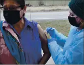  ?? IRIS SAMUELS — THE ASSOCIATED PRESS ?? Sherry Cross Child, a Canadian resident of Stand Off, Alberta, receives a COVID-19 vaccine at the PieganCarw­ay border crossing near Babb, Montana.