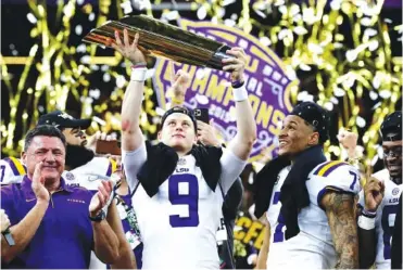  ?? AP PHOTO BY SUE OGROCKI ?? LSU quarterbac­k Joe Burrow holds the trophy as safety Grant Delpit looks on after LSU beat Clemson 42-25 in the College Football Playoff national championsh­ip game on Jan. 13 in New Orleans.