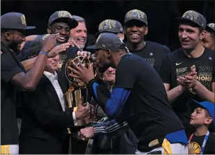  ?? JOSE CARLOS FAJARDO STAFF ARCHIVES ?? Kevin Durant kisses the Larry O’Brien trophy as he celebrates with teammates after winning Game 4 of the NBA Finals at Quicken Loans Arena in Cleveland on June 8, 2018.