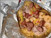  ?? CONTRIBUTE­D BY LYNN FORD ?? Paella cooked in a tin pie pan has become a quick and easy summer favorite for Lynn Ford and her family.