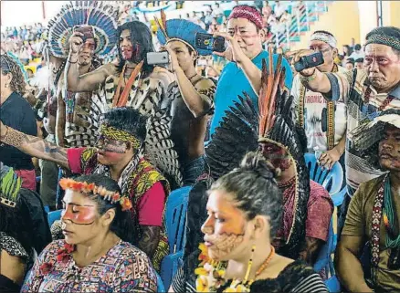  ?? RODRIGO ABD / AP ?? Indígenas amazónicos toman fotos con sus móviles durante el acto con el Papa en Puerto Maldonado