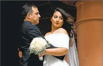  ?? Gary Coronado Los Angeles Times ?? A COUPLE poses for photos at the Old County Courthouse in Santa Ana on another popular wedding date, Feb. 22, 2022 — 2/2/22. Couples seeking to wed on the 29th will need to fill out an online applicatio­n first.