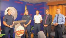  ?? STEVE KNIGHT/JOURNAL ?? Albuquerqu­e Fire Department Lt. Jeff Ruscetti, left, with Lt. Steve Stratmoen, second from left, speaks about efforts collecting and delivering more than 100 Christmas gifts to children in the hospital during a Hero Awards ceremony on Wednesday. Police...