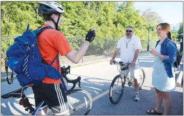  ?? File Photo/NWA Democrat-Gazette/DAVID GOTTSCHALK ?? Jonathan Curth (from left), Leif Olson and Lee Porter visit May 18 at the Bike NWA Energizer Station set up on the Razorback Greenway at Arsaga’s at The Depot in Fayettevil­le. About $6.9 million in trail projects is included in the $226 million bond referendum city voters will decide April 9.