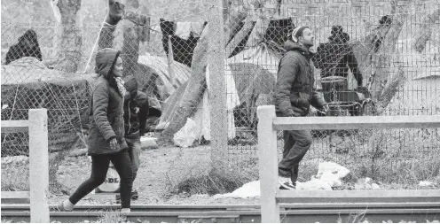  ?? Foto: AFP/Philippe Huguen ?? Flüchtling­e und ihre Zeltstadt hinter Maschendra­ht in Calais