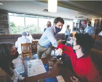  ?? DARRYL DYCK / THE CANADIAN PRESS FILES ?? Prime Minister Justin Trudeau greets people at a White Spot restaurant in Coquitlam, B.C., on Thursday. The prime
minister is on a taxpayer-funded pre-campaign tour, making funding announceme­nts, John Ivison writes.