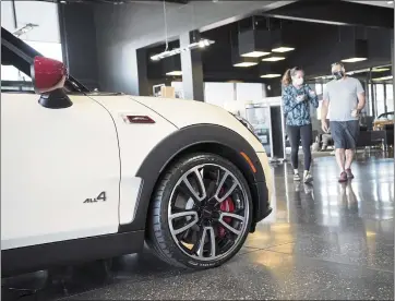  ?? DAVID ZALUBOWSKI — THE ASSOCIATED PRESS ?? Customers walk past a 2022Clubma­n John Cooper Works model for sale on the floor of a Mini showroom in Highlands Ranch, Colo. The consumer confidence index for January is 113.8, still high despite inflation for almost every good.