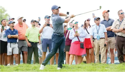  ?? MICHAEL REAVES/GETTY IMAGES ?? Rory McIlroy plays a shot on the 17th hole, his most challengin­g of the day, during a soggy first round at the BMW Championsh­ip on Thursday.