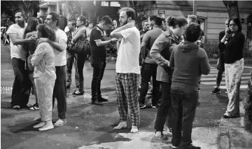  ?? — AFP photo ?? People gather on a street in downtown Mexico City during an earthquake.