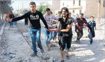  ?? Thaer Mohammed AFP/Getty Images ?? SYRIANS RESCUE victims from the rubble of a collapsed building after a U.S. airstrike in northern Syria on July 19. The bombing of Al Tokhar killed civilians who were believed to have fled the area, the Pentagon said.