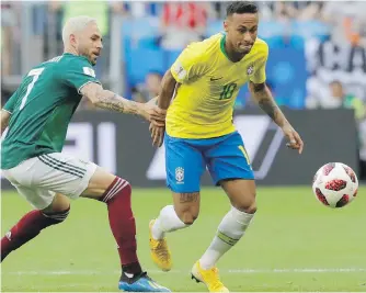  ??  ?? Mexico’s Miguel Layun, left, hangs on to Brazil’s Neymar, as he vies for the ball during their round-of-16 match in Samara, Russia, on Monday. Brazil won 2-0.