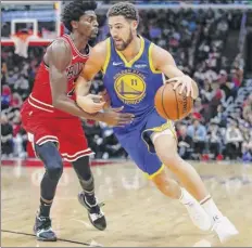  ?? Kamil Krzaczynsk­i / Associated Press ?? the Warriors’ Klay thompson, guarded by the Bulls’ Justin Holiday, got 42 of his 52 points on a record 14 3-pointers.