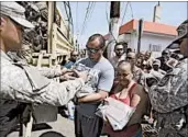  ?? CARLOS GIUSTI/AP ?? The National Guard distribute­s water to storm survivors Sunday in San Juan. Maria’s death toll is 10 in Puerto Rico.