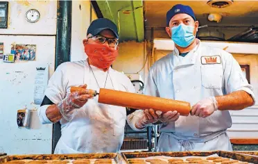  ?? ANTHONY JACKSON/JOURNAL ?? Owner Pratt Morales, left, and his son, Chris Morales, in front of trays of fresh biscochito­s inside the Golden Crown Panaderia. Pratt Morales sought funding from the federal Paycheck Protection Program to help tide over his bakery, and has already received his money.