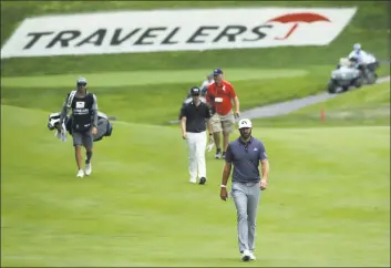  ?? Frank Franklin II / Associated Press ?? Dustin Johnson, bottom, walks up the 15th fairway during the third round of the Travelers Championsh­ip on Saturday.