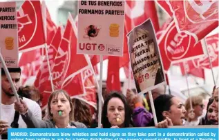  ?? ?? MADRID: Demonstrat­ors blow whistles and hold signs as they take part in a demonstrat­ion called by \UPVUZ MYVT 0UKP[L_ [V HZR MVY H IL[[LY KPZ[YPI\[PVU VM [OL NYV\W»Z YLJVYK WYVÄ[Z PU MYVU[ VM H )LYZORH store in Madrid. — AFP