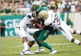  ?? TAMPA BAY TIMES ?? Georgia Tech defensive back Malik Rivera tackles South Florida’s Darnell Salomon in last week’s 49-38 loss. Tech players are still adapting to the new defense.