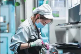  ?? PENG YUAN / XINHUA ?? An employee works on the photovolta­ic production line of a tech company in the Inner Mongolia autonomous region.