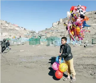  ??  ?? A young boy sells balloons in Kabul, on Thursday. An aid group said Thursday that nearly a third of all children in war-torn Afghanista­n are unable to attend school, leaving them at increased risk of child labor and recruitmen­t by armed groups. (AP)