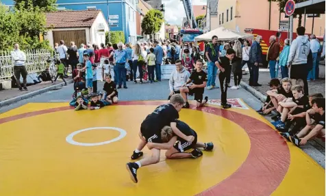  ?? Fotos: Leonie Steinhardt ?? Markfest Mering: Zur Sache ging es mitten auf der Straße. Die Ringermann­schaft vom TSC Mering bei einer Vorführung.