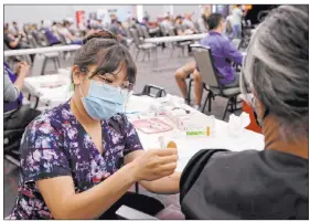  ?? K.M. Cannon Las Vegas Review-journal @Kmcannonph­oto ?? Deanna Chea of UNLV Medicine gives a vaccinatio­n shot Monday at the school. COVID cases in Nevada have risen above the two-week daily average recently.