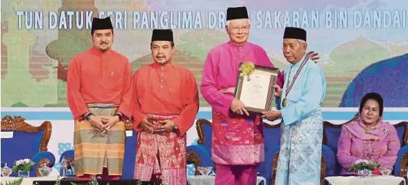  ?? [FOTO ZULFADHLI ZULKIFLI/BH] ?? Najib menyampaik­an sijil penghargaa­n kepada Tokoh Maal Hijrah 1439 Peringkat Kebangsaan kepada bekas Ketua Menteri dan Yang Dipertua Negeri Sabah, Tun Sakaran Dandai sambil disaksikan Jamil Khir, Asyraf Wajdi dan isteri Perdana Menteri, Datin Seri...