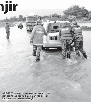  ??  ?? ANGGOTA bomba membantu menolak kereta pengguna jalan raya di Sematan yang rosak ketika melalui kawasan banjir.