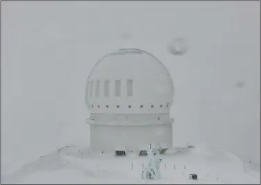  ?? (AP/Canada-France-Hawai’i Telescope) ?? Snow is seen atop the summit of Mauna Kea in Hawaii on Monday. A strong storm packing high winds and extremely heavy rain flooded roads and downed power lines and tree branches across Hawaii.