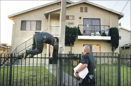  ?? Rick Loomis Los Angeles Times ?? LAPD HARBOR DIVISION officers enter a housing complex to serve notice of an injunction against members of the 204th Street gang. Los Angeles’ sprawling network of injunction­s has long drawn criticism from activists and the American Civil Liberties Union.