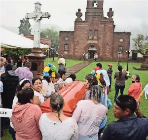  ?? ?? Los féretros son cargados por habitantes de la comunidad