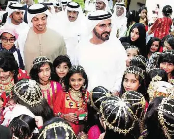  ??  ?? Popular leader Shaikh Mohammad and Shaikh Mansour are greeted by children at Atika Bin Zayed Primary School for girls in Khor Fakkan.