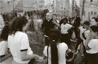  ?? Robson Ventura/folhapress ?? O professor Paulo Magalhães, 53 anos, dá aula para alunos da Emef Duque de Caxias em rua do Glicério (região central de São Paulo); iniciativa, chamada de Aula Pública, acontece ao menos uma vez por mês