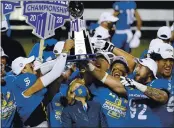  ?? PHOTO BY ETHAN MILLER — GETTY IMAGES ?? San Jose State Spartans AD Marie Tuite, center, looks up as players, including quarterbac­k Nick Starkel (17) and defensive lineman Cade Hall (92), hold up the championsh­ip trophy after defeating the Boise State Broncos 34-20to win the Mountain West Football Championsh­ip at Sam Boyd Stadium on Dec. 19in Las Vegas.