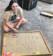  ?? PHOTO: SYLVIE BROSNAHAN ?? Got the edges done . . . Marnie Brosnahan (14) works on a puzzle in her Roslyn living room.