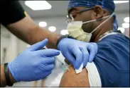  ?? LYNNE SLADKY — THE ASSOCIATED PRESS FILE ?? A health care worker receives a Pfizer COVID-19booster shot at Jackson Memorial Hospital in Miami on Oct. 5.