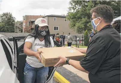  ?? ASHLEE REZIN GARCIA/SUN-TIMES ?? Anicia Miller, 18, receives a Chromebook laptop and other dorm essentials at the CHA’s 10th annual “Take Flight College SendOff.”