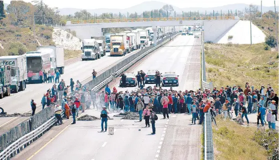  ??  ?? El cierre de la autopista Puebla-Orizaba, a la altura del kilómetro 188, en la que se ve ya una larga fila de camiones.