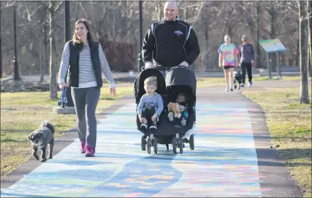  ??  ?? A family walks along the Schuylkill River Trail art mural at Pottstown Riverfront Park. Community members will walk along a 1-mile loop of the trail at the park for a Medicine on the Move program.
